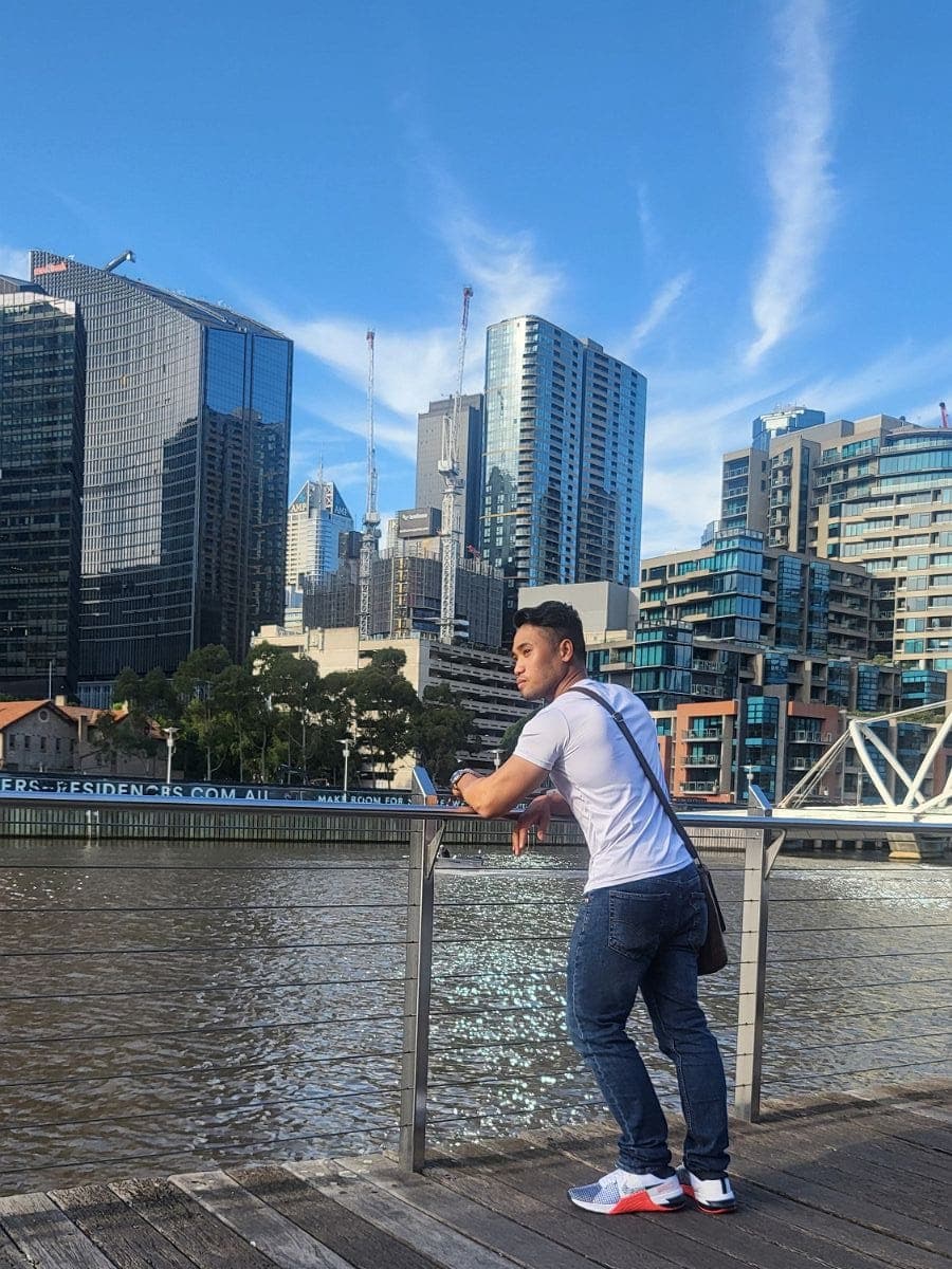 PJ Fabia standing by a river, looking out over the water